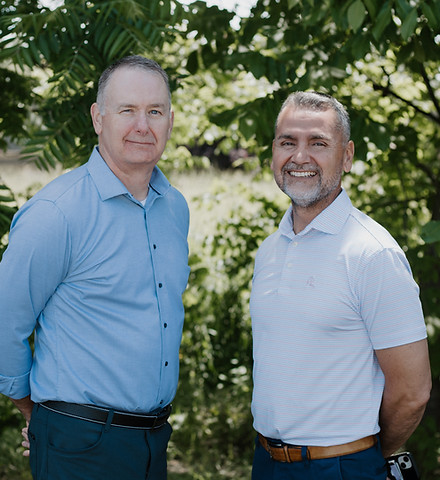 Owners of Clark-Arias Physical Therapy, Mike Clark and George Arias stand outside and smile at the camera.